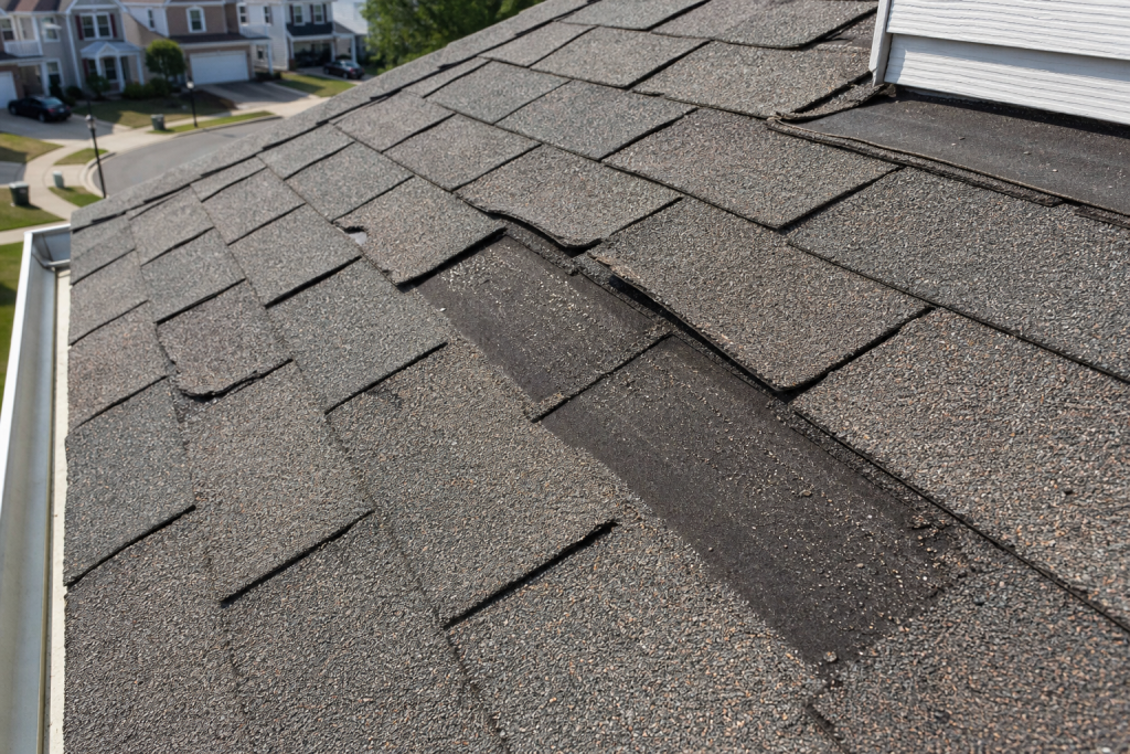Damaged curling shingles on a Fairfax VA home showing UV deterioration