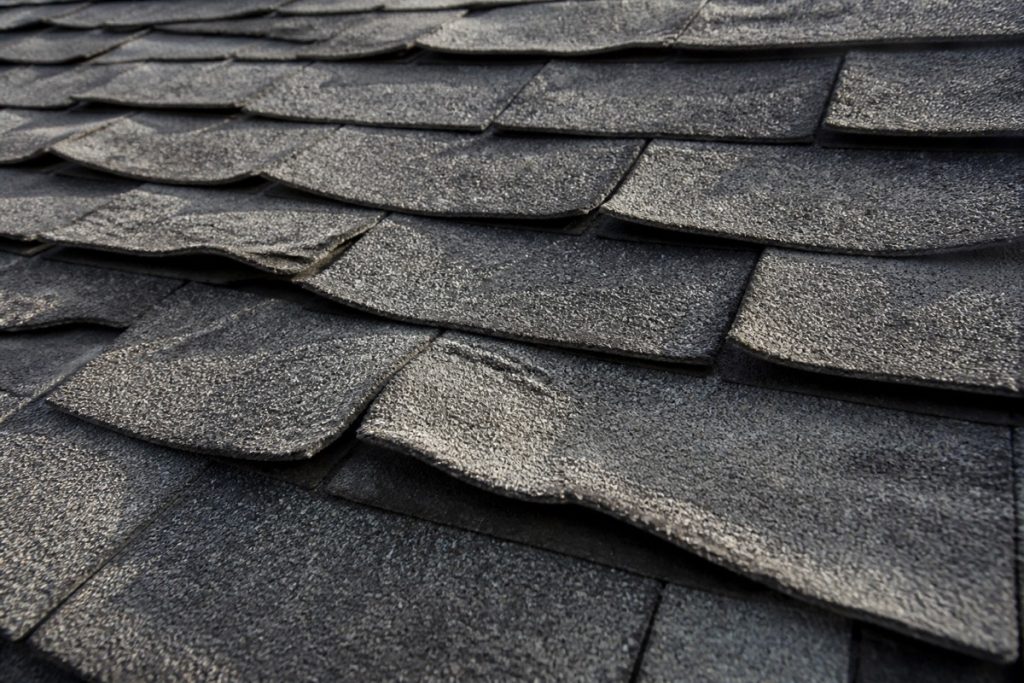 Curling and cupping asphalt shingles signaling a roof near the end of its life