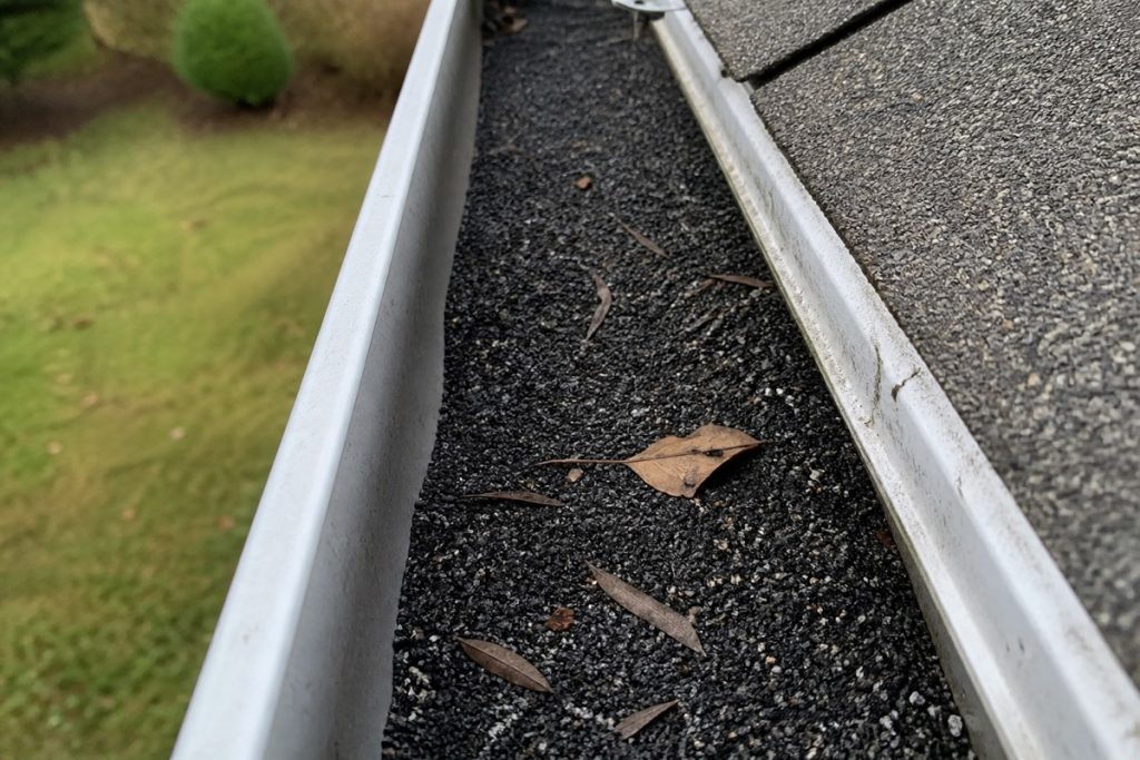 Shingle granules collected in a gutter, a sign the shingles are wearing out